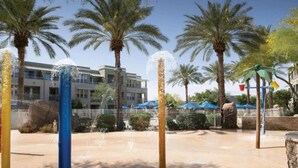 A water feature with multiple jets, palm trees, and a building with balconies in the background. - 2 Bedroom - Marriott's Canyon Villas at Desert Ridge - Full Resort Access (Phoenix)
