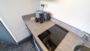 Une petite cuisine équipée d’un grille-pain, d’une bouilloire et d’une machine à café intégrés.
