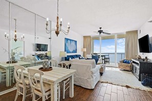 Relax in the spacious living area with a dining set, comfortable seating, and a large window offering a view of the outdoors.