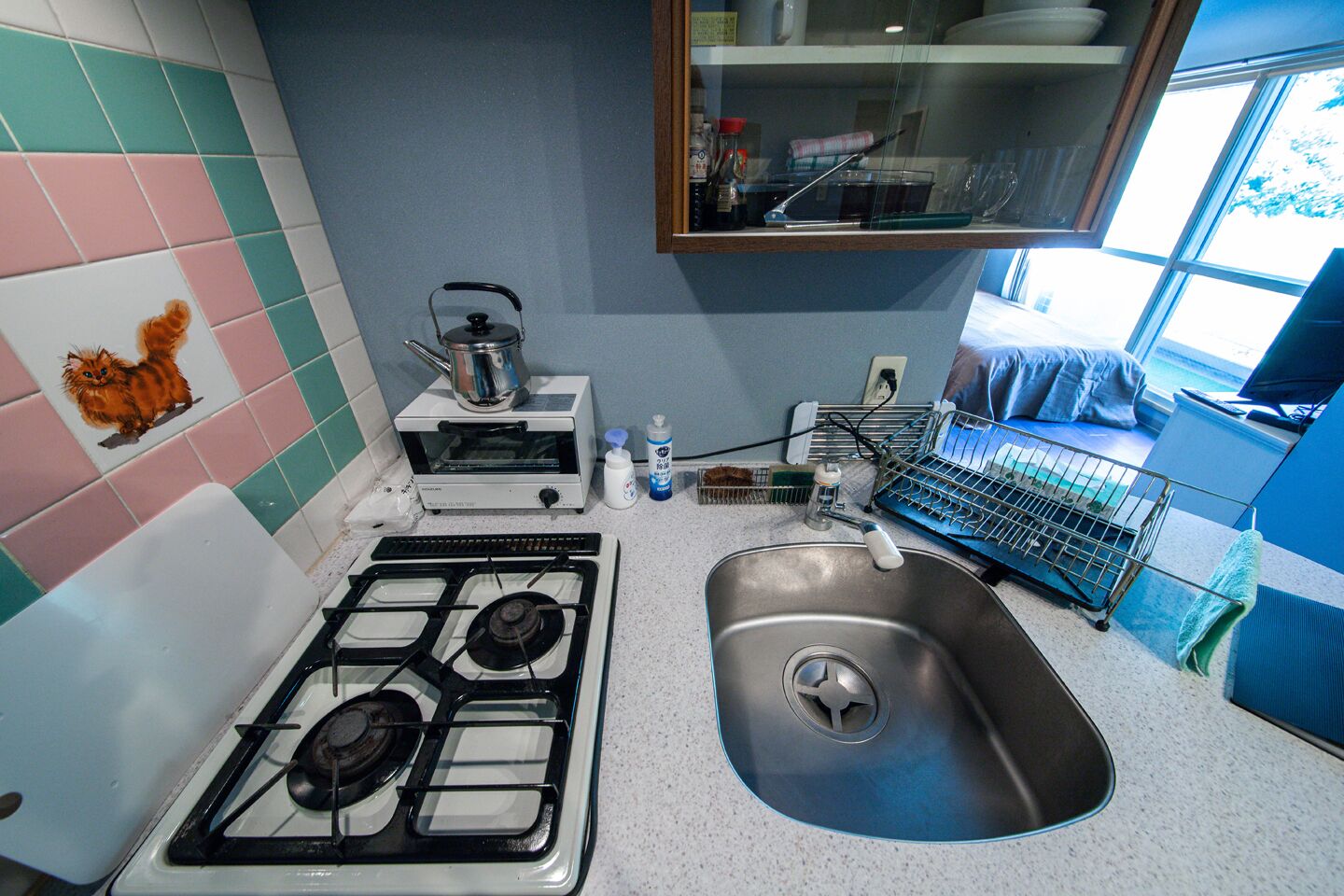 Een keuken met een gasfornuis, een spoelbak en een magnetron.