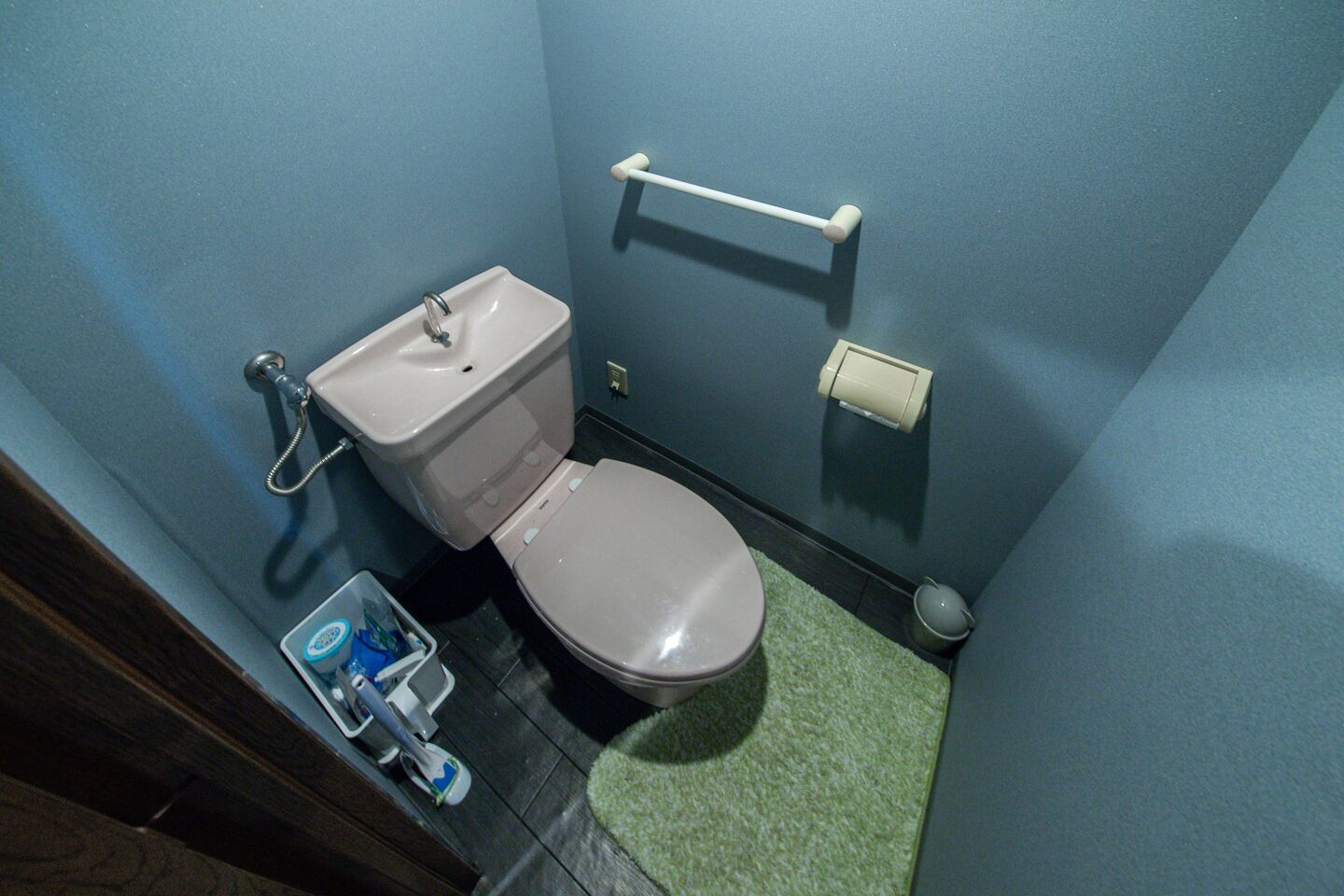 A small bathroom with a toilet, sink, and hand dryer.