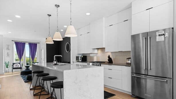 A modern kitchen with a large island, stainless steel appliances, and pendant lighting. - Stylish Nashville Stay • Skyline Views (Nashville)
