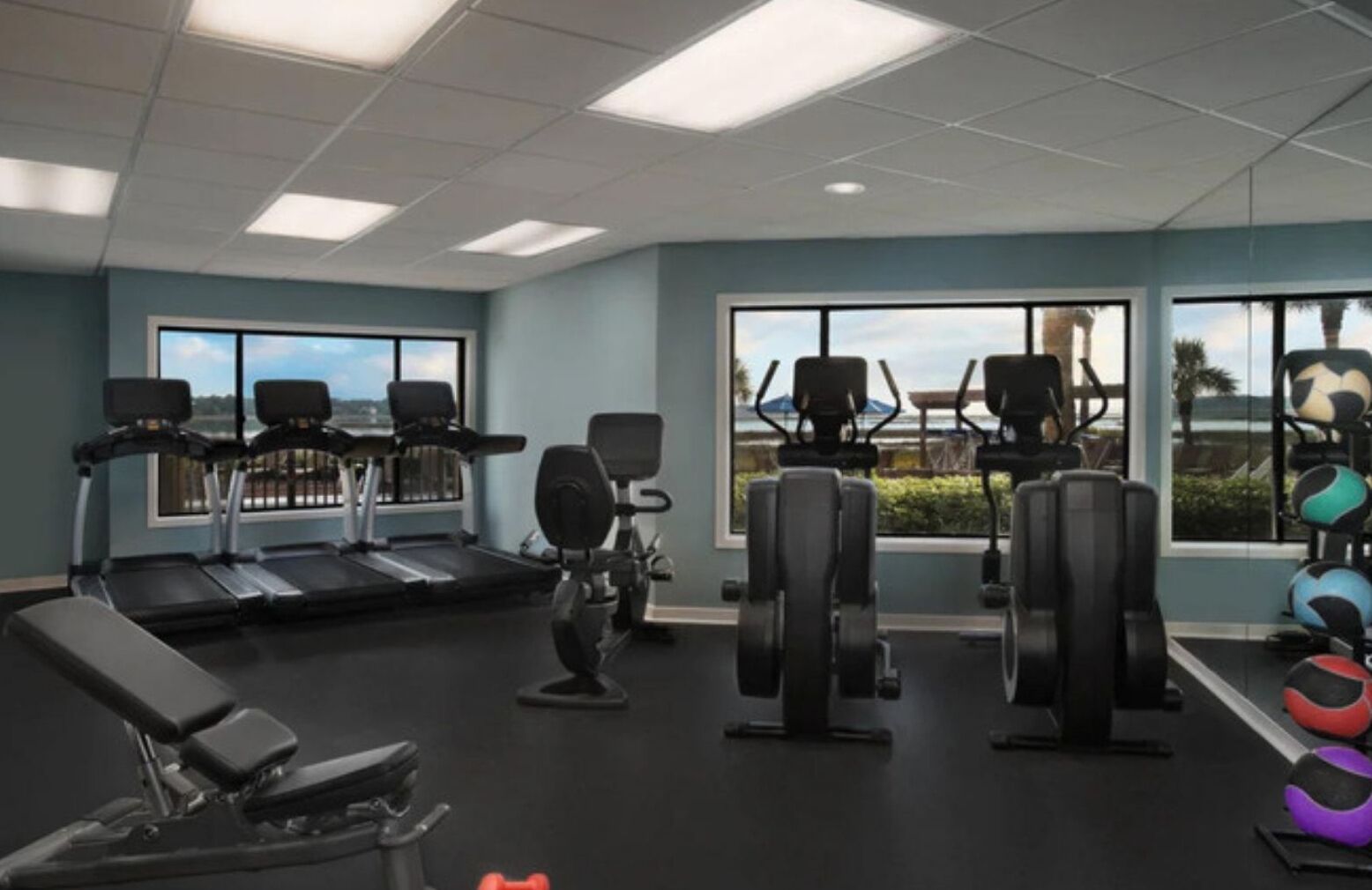 A gym with treadmills, weight machines, and exercise balls.