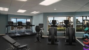A gym with treadmills, weight machines, and exercise balls.