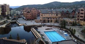 Un hôtel doté d’une piscine, d’un quai et offrant une vue sur les bâtiments et les collines environnants.