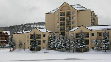 A multi-story hotel with a symmetrical facade, large windows, and a snow-covered roof.