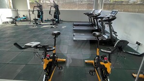 Une salle de sport équipée de vélos d’appartement, de tapis de course et d’appareils de musculation.
