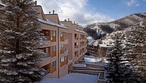 A multi-story hotel with balconies, set against a snowy mountain backdrop. - 2 Bedroom - Marriott's StreamSide at Vail - Birch, Douglas, and Evergreen - Full Resort Access (Vail)
