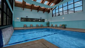 An indoor swimming pool with clear blue water, wooden beams on the ceiling, and a row of chairs along the poolside. - 2 Bedroom - Marriott's StreamSide at Vail - Birch, Douglas, and Evergreen - Full Resort Access (Vail)