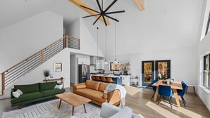 Un grand espace de vie comprenant un escalier, une cuisine et un coin repas.