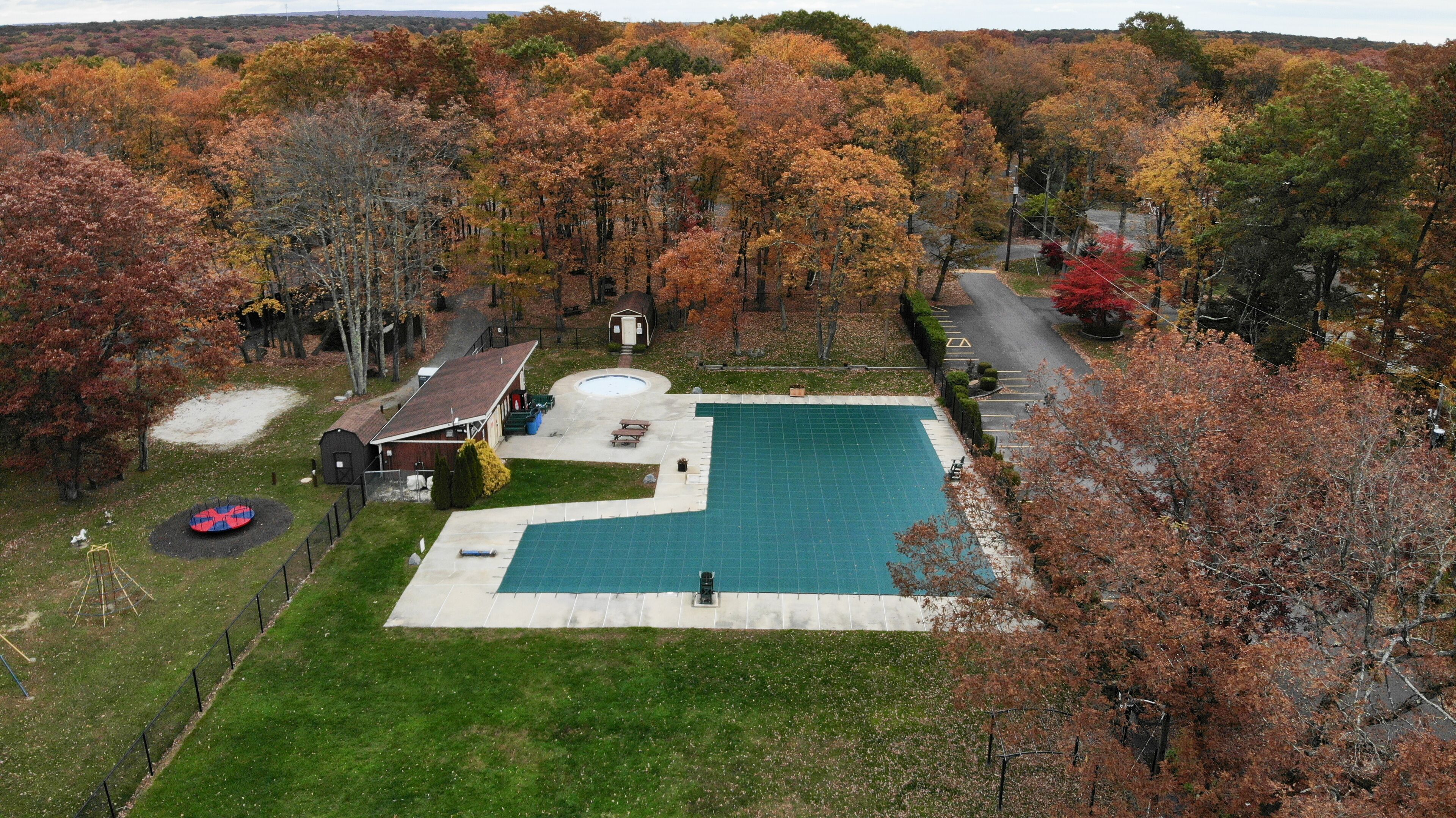 A residential area with a swimming pool, a small shed, and a playground.