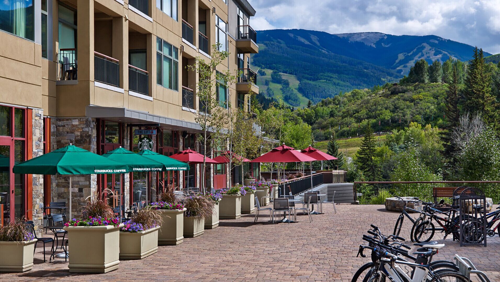 Ein Hotel mit Außenbereich, Starbucks Kaffee und Blick auf die Berge.