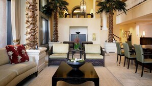 Eine großzügige Lobby mit einer Couch, Sesseln, einem Couchtisch und einer Rezeption.