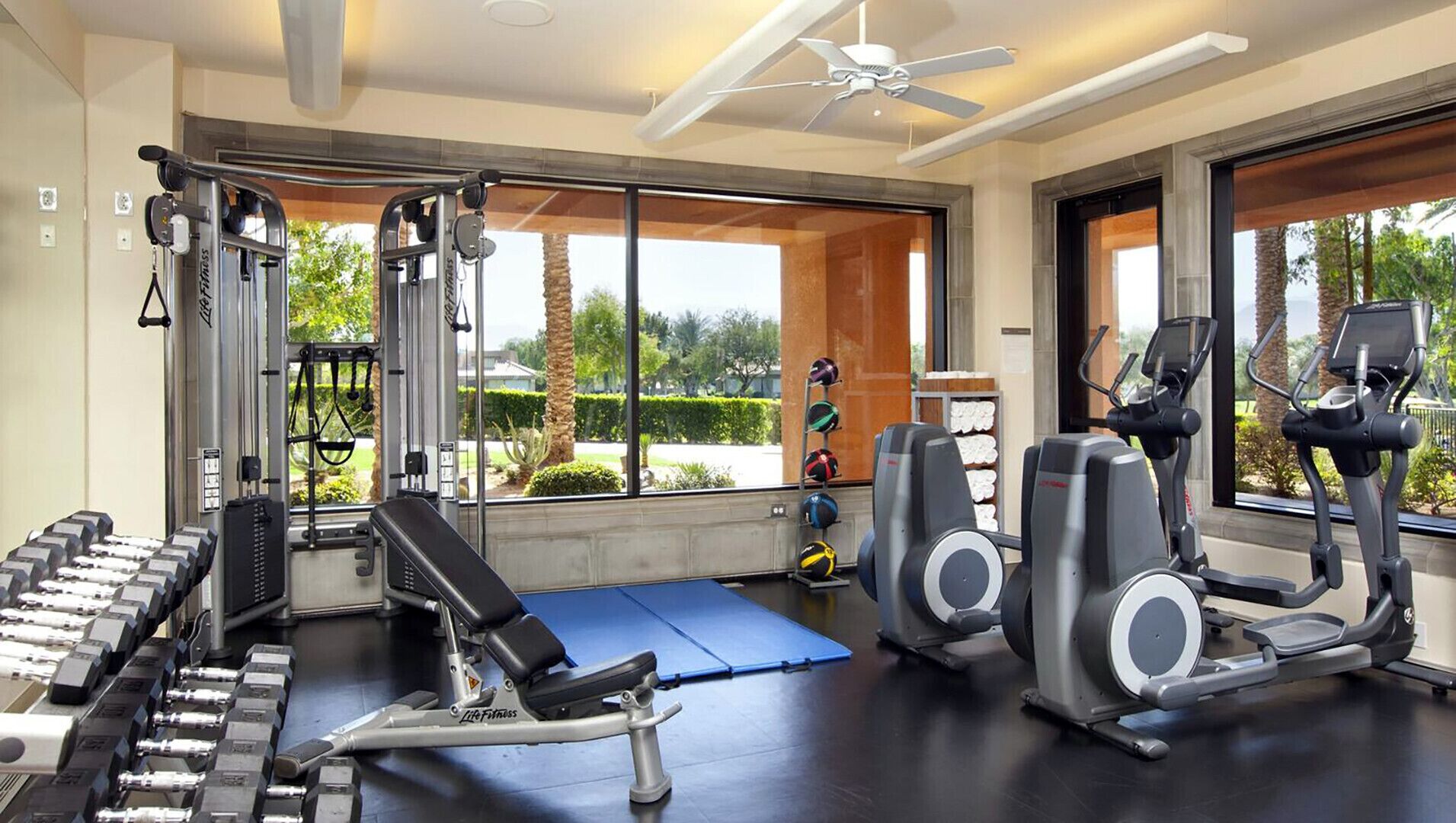 Ein Fitnessstudio mit Kraftgeräten, Laufbändern und Kurzhanteln.