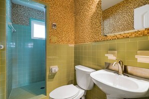 Un baño con ducha, inodoro y lavabo.