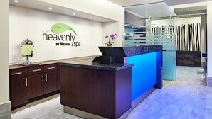 Un área de recepción con un mostrador de madera, una vitrina de vidrio y un letrero en la pared que dice "heavenly by Westin /spa".