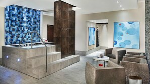 A modern lobby with a large blue mosaic wall, a central staircase, and a seating area with a coffee table. - Studio - Westin Lagunamar Ocean Resort - Full Resort Access (Cancún)