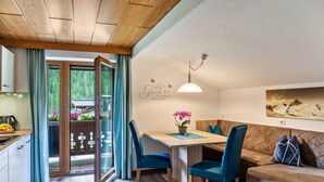 A modern kitchen with a dining area, a sofa, and a view of the outdoors. - "Haus Alpenheim Apartment 1" with Mountain View, Balcony & Wi-Fi (Tux)