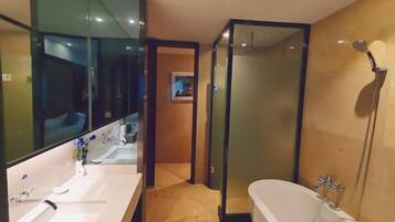 Een moderne badkamer met een grote spiegel, twee wastafels, een badkuip en een douchecabine van glas.
