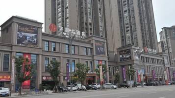 Een hotel met meerdere verdiepingen, grote ramen en diverse banners met advertenties voor verschillende diensten.