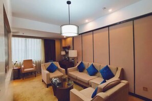 A modern hotel room with a sofa set, a coffee table, and a lamp. - Feng Du Hotel (Fengdu County)