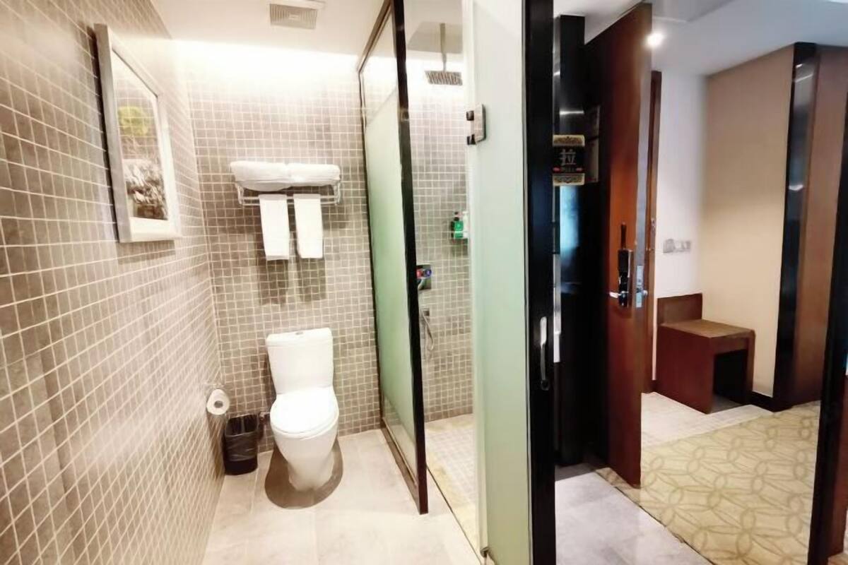 Un baño moderno con inodoro, cabina de ducha de vidrio y lavabo.