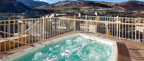Uma banheira de hidromassagem em um deck com vista para as montanhas.