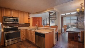 A modern kitchen with wooden cabinets, stainless steel appliances, and a central island.