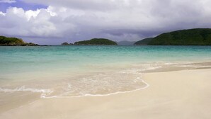 A beach with clear turquoise water and a sandy shore.