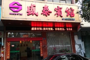 Une enseigne d’hôtel portant le nom « 威泰宾馆 » et un numéro de téléphone.