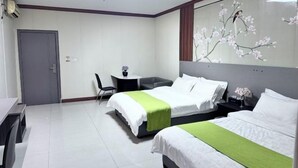 Habitación de hotel con dos camas, un escritorio, una silla y un ventanal grande.