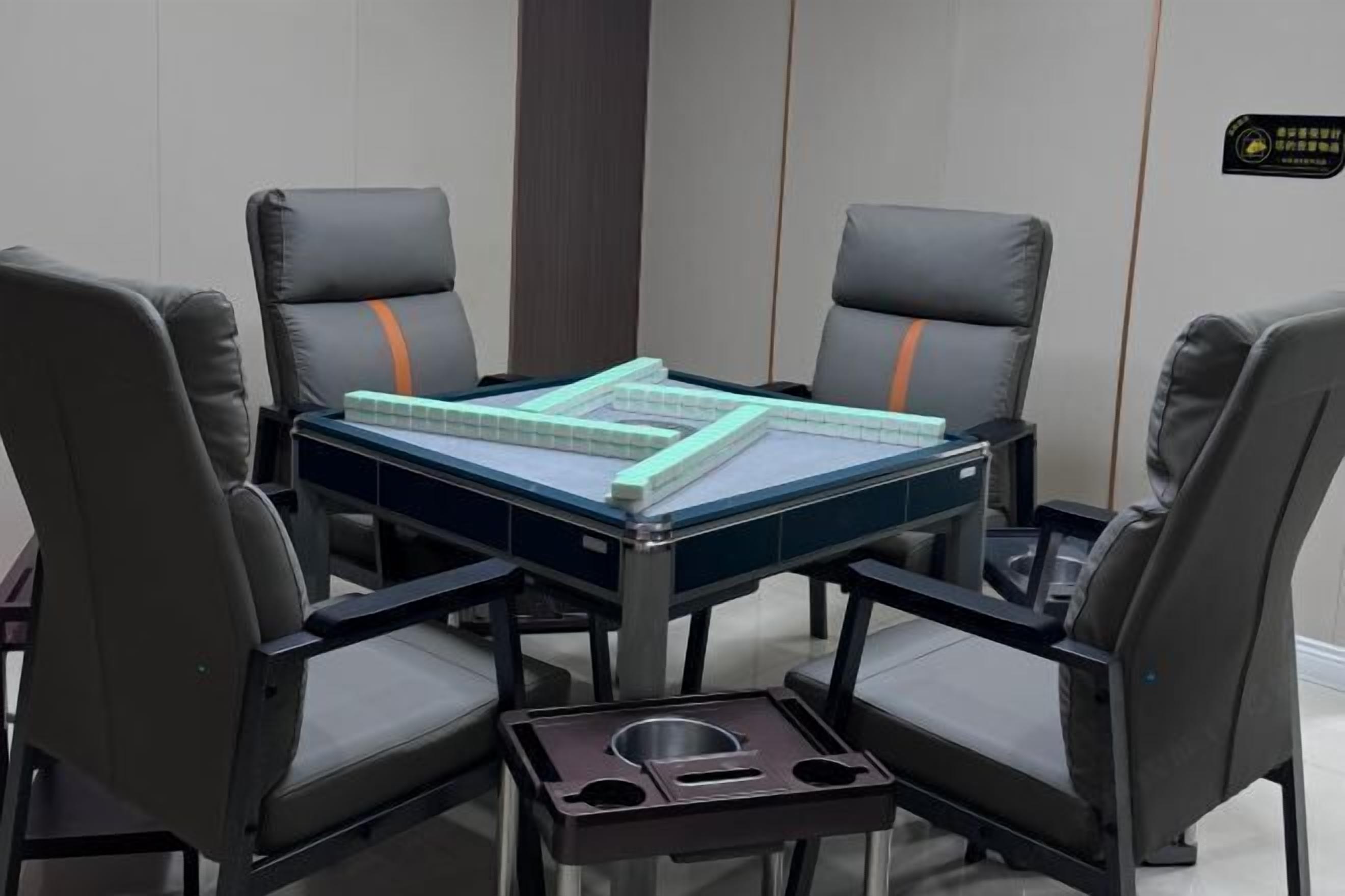 A conference room with a table, four chairs, and a small trash bin.
