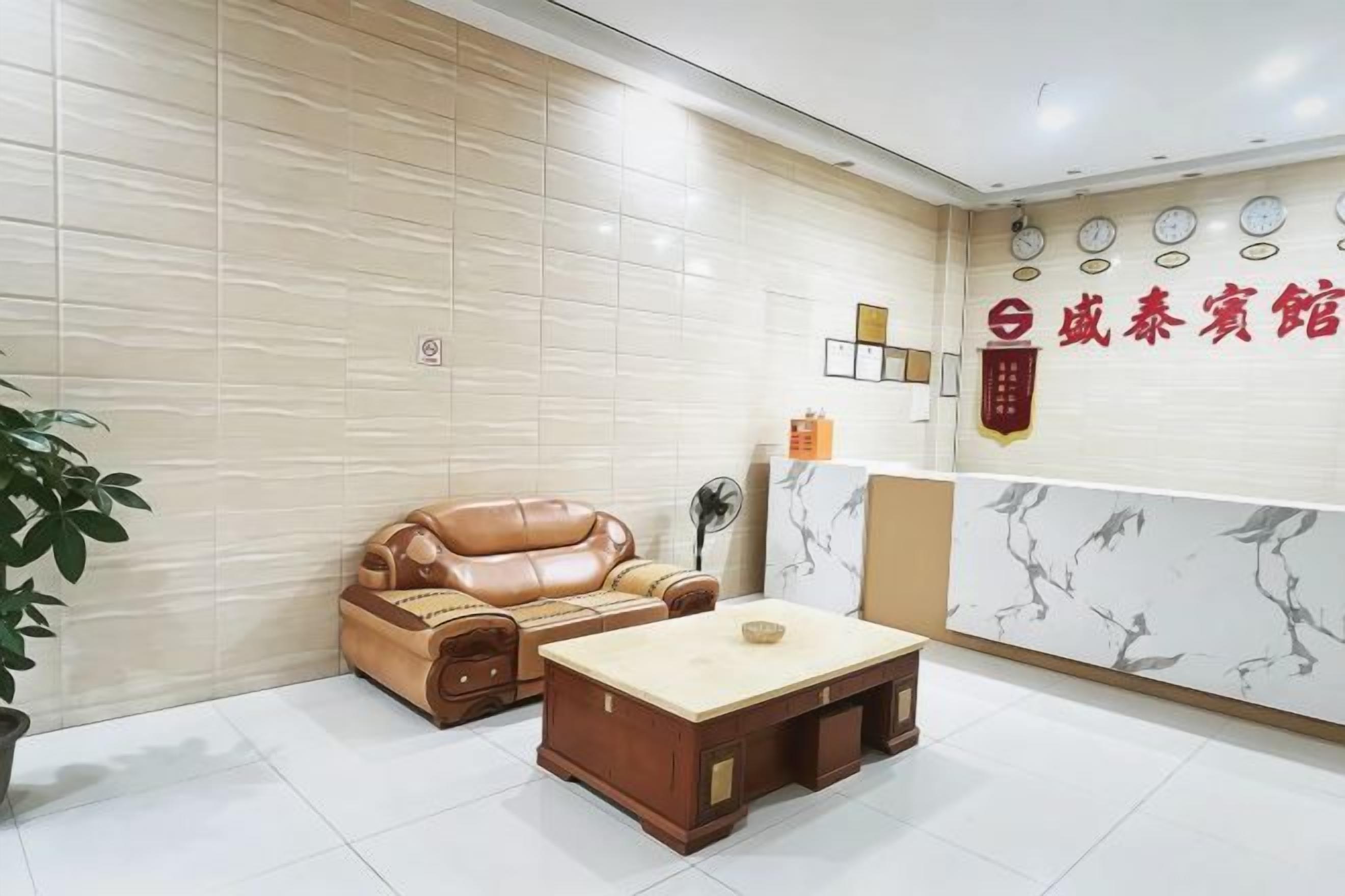 A reception area with a sofa, a coffee table, and a wall with a logo.