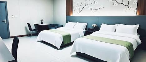 Habitación de hotel con dos camas, un escritorio y una silla.
