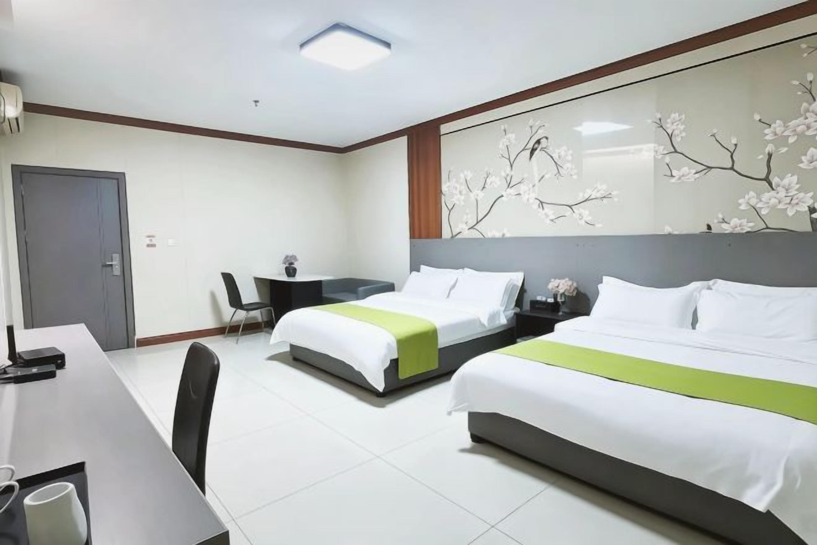 Een hotelkamer met twee bedden, een bureau en een stoel.