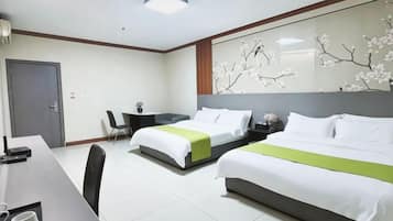 A hotel room with two beds, a desk, and a chair.