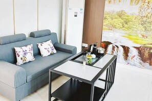 Ein modernes Wohnzimmer mit einer Couch, einem Couchtisch und einem Wandgemälde eines Wasserfalls.