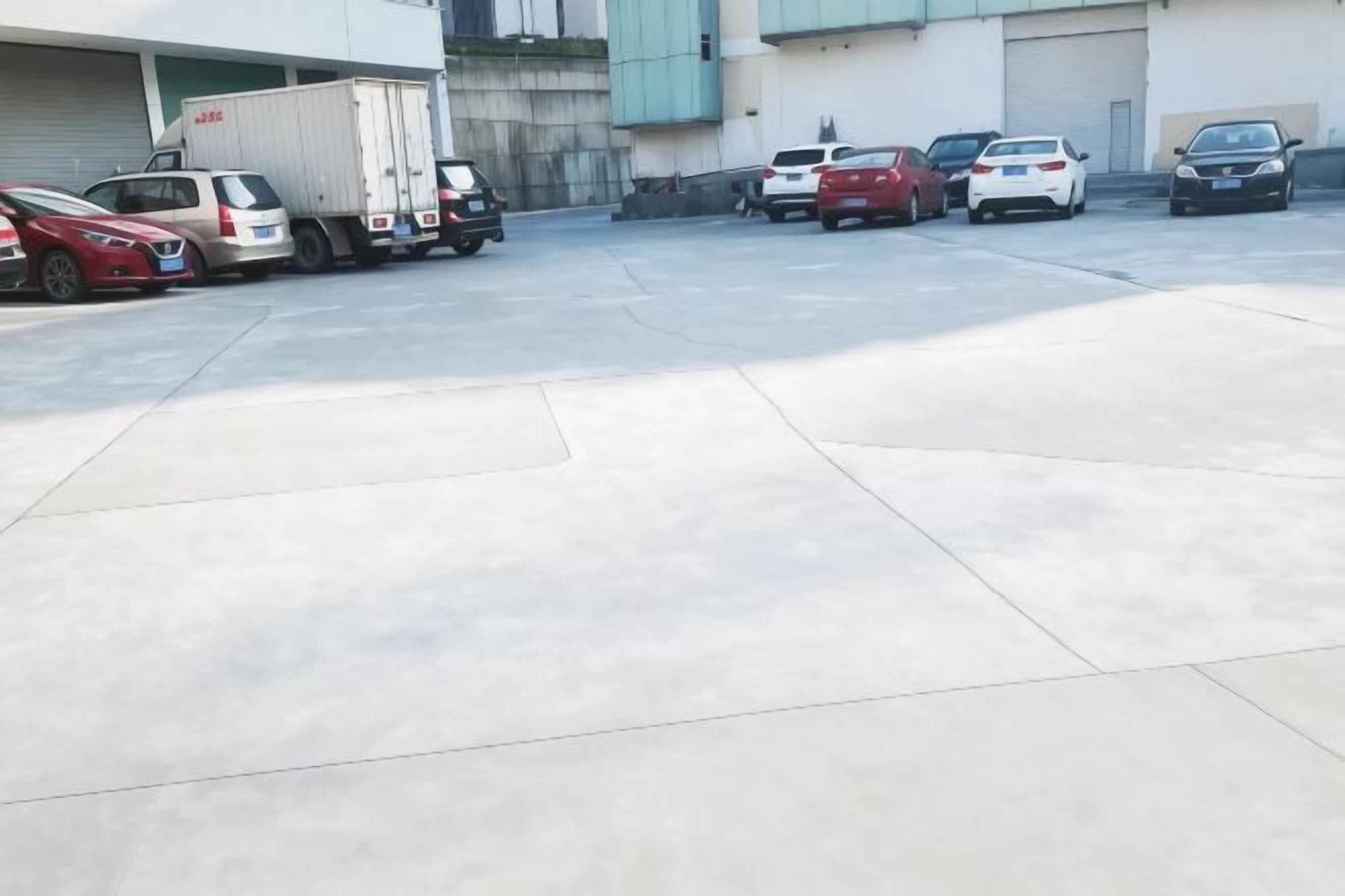 A parking lot with several cars and a truck.