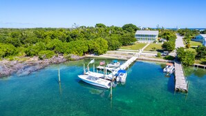 Un port de plaisance avec des bateaux amarrés, une eau claire et, au fond, un bâtiment doté d’une grande fenêtre.