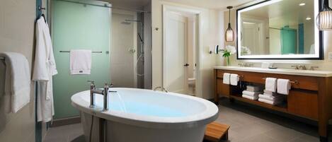 A modern bathroom with a freestanding bathtub, a walk-in shower, and a vanity with a large mirror.