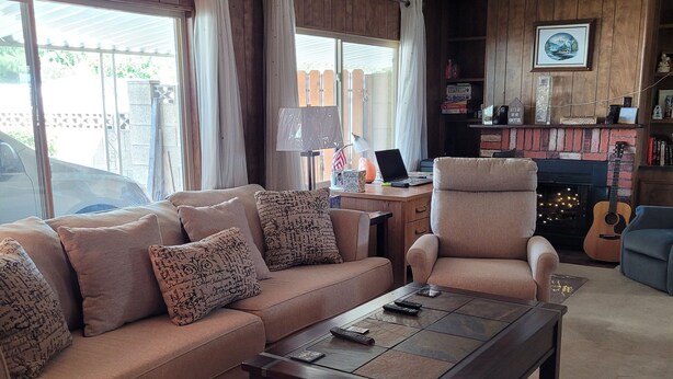 A living room with a sofa, armchair, coffee table, and a fireplace.