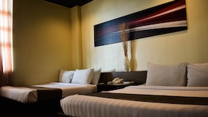 A hotel room with two beds, a bedside table with a phone, and a painting on the wall.