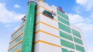 A tall building with a green and white facade, featuring a prominent sign for 'Green Windows Dormitory'.