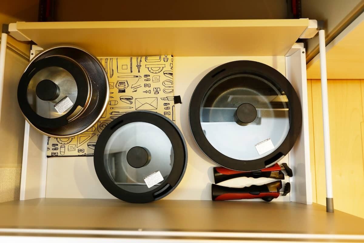 Un contenedor de almacenamiento con tres objetos grandes y circulares, quizás ruedas o rodillos, y un tejido estampado en su interior.