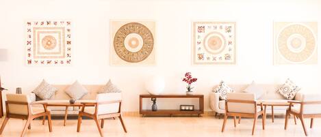 Una sala de estar moderna con un conjunto de sofá, una mesita de centro y decoración en la pared.