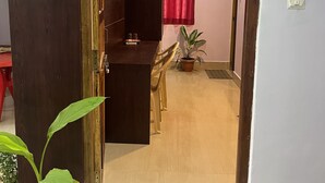 A doorway leading to a room with a wooden cabinet, a potted plant, and a sign indicating room number 101. - Purnima Resort Neil Island (Port Blair)