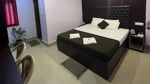A hotel room with a bed, bedside table, air conditioning unit, and a potted plant. - Purnima Resort Neil Island (Port Blair)