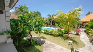 A pool surrounded by lush greenery and a clear blue sky.