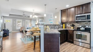 Una cocina moderna con alacenas de madera oscura, electrodomésticos de acero inoxidable y una isla central.