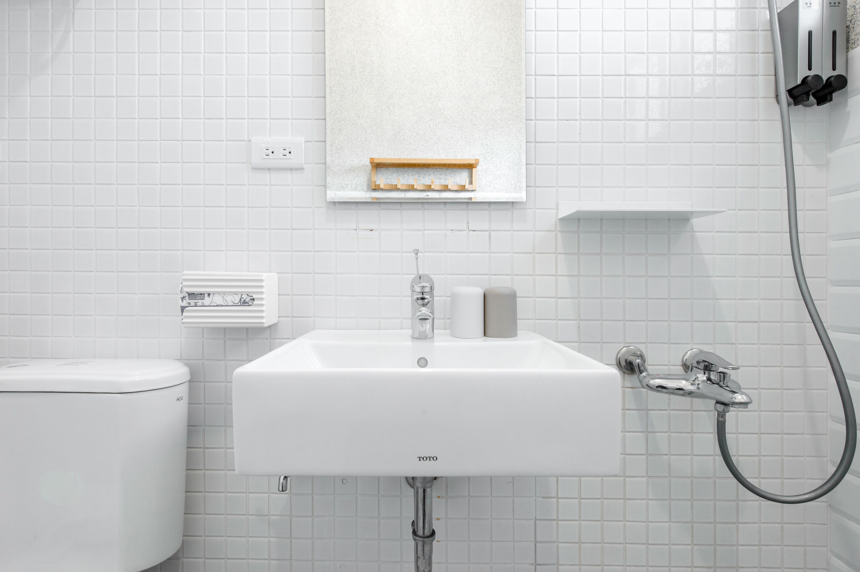 Een badkamer met een wit wastafel, toilet en douche.